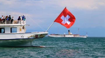 Swiss flag waving from a Lake Geneva paddle steamboat