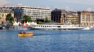 CGN's Simplon paddle steam boat in Geneva with a Mouette passenger ferry passing in the foreground.